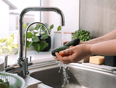 Woman washing cucumber