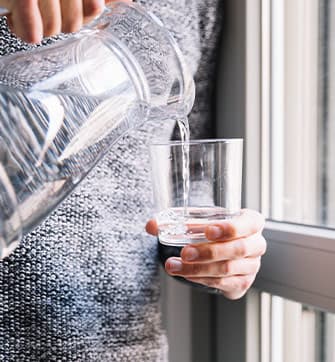man-pouring-water-near-window